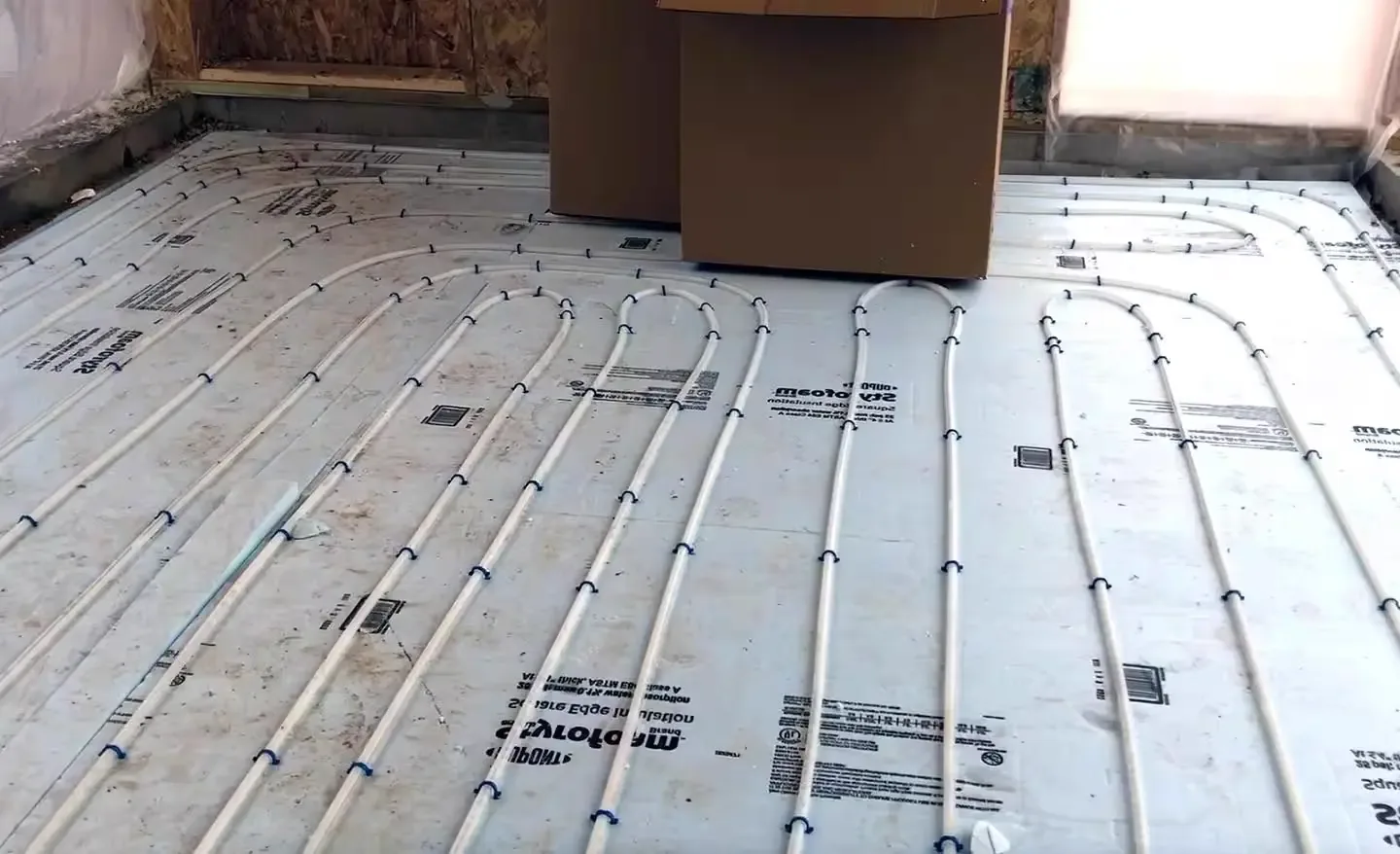 Hydronic radiant floor heating tubes laid out on insulation before flooring goes down