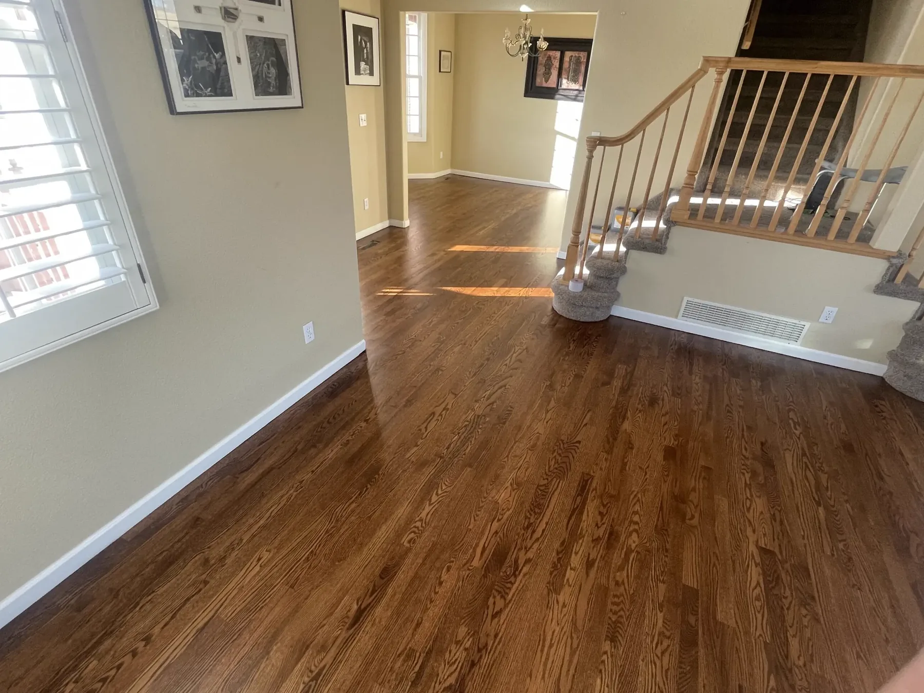 Refinished hardwood floor running through a hallway to a staircase