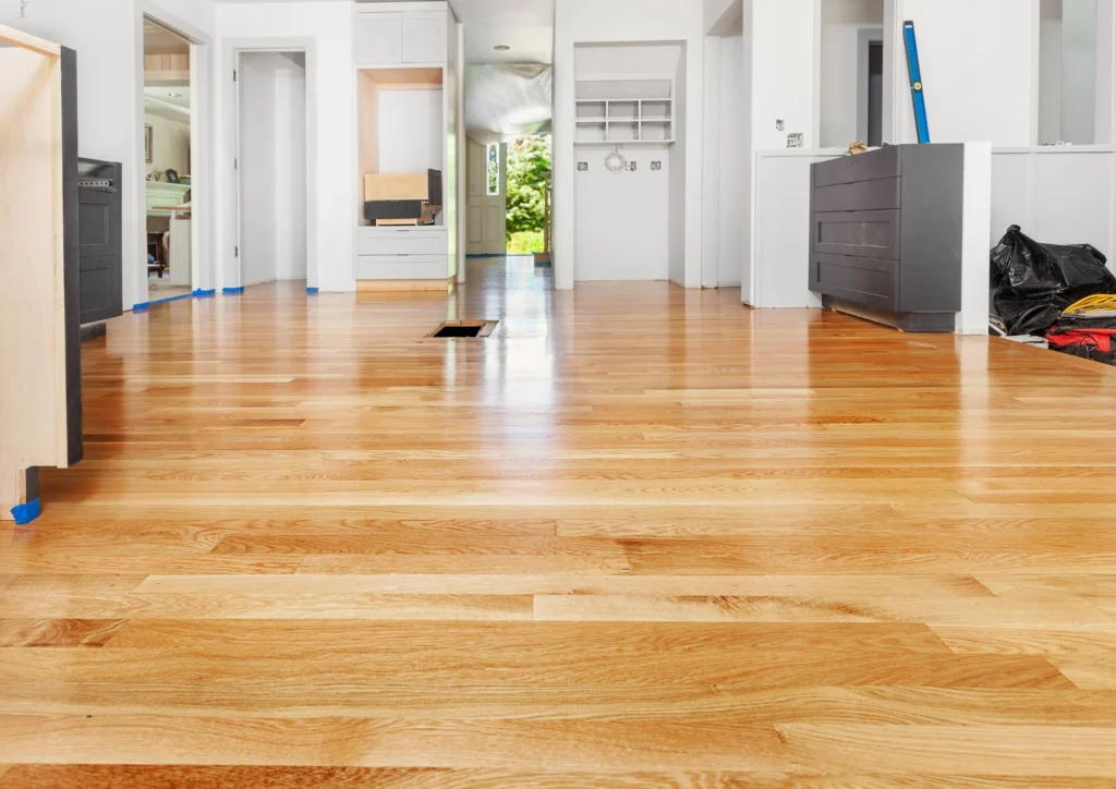 Newly installed wide-plank light oak hardwood floor in an open hallway
