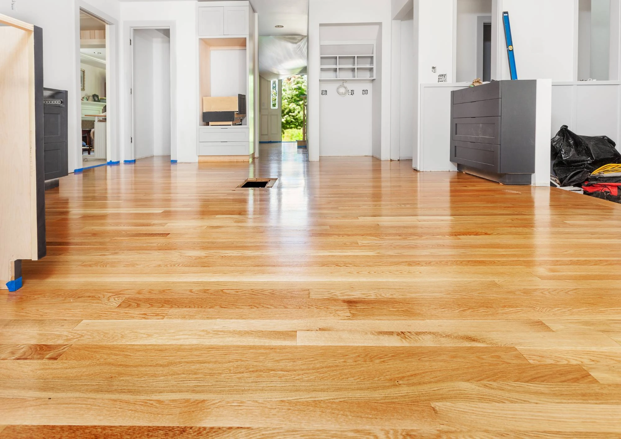 Newly installed wide-plank light oak hardwood floor in an open hallway