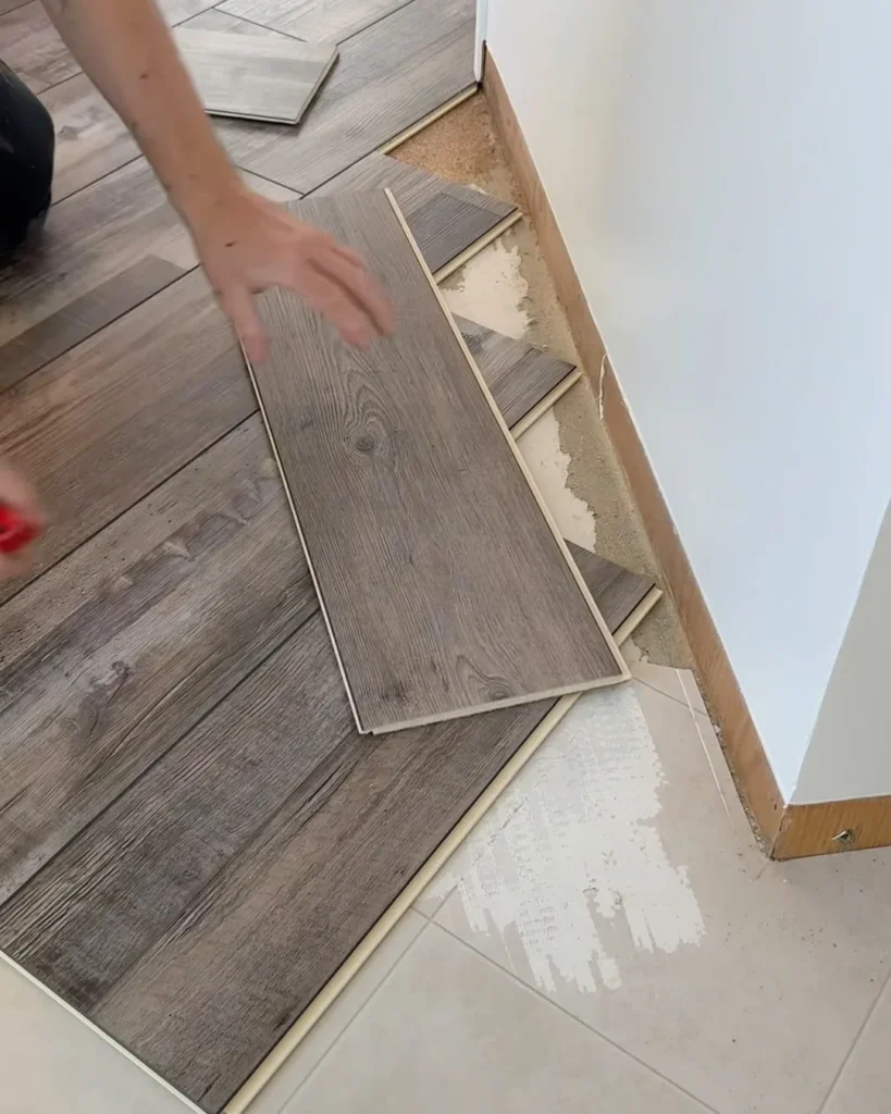 Grey wood-look vinyl plank being clicked into place